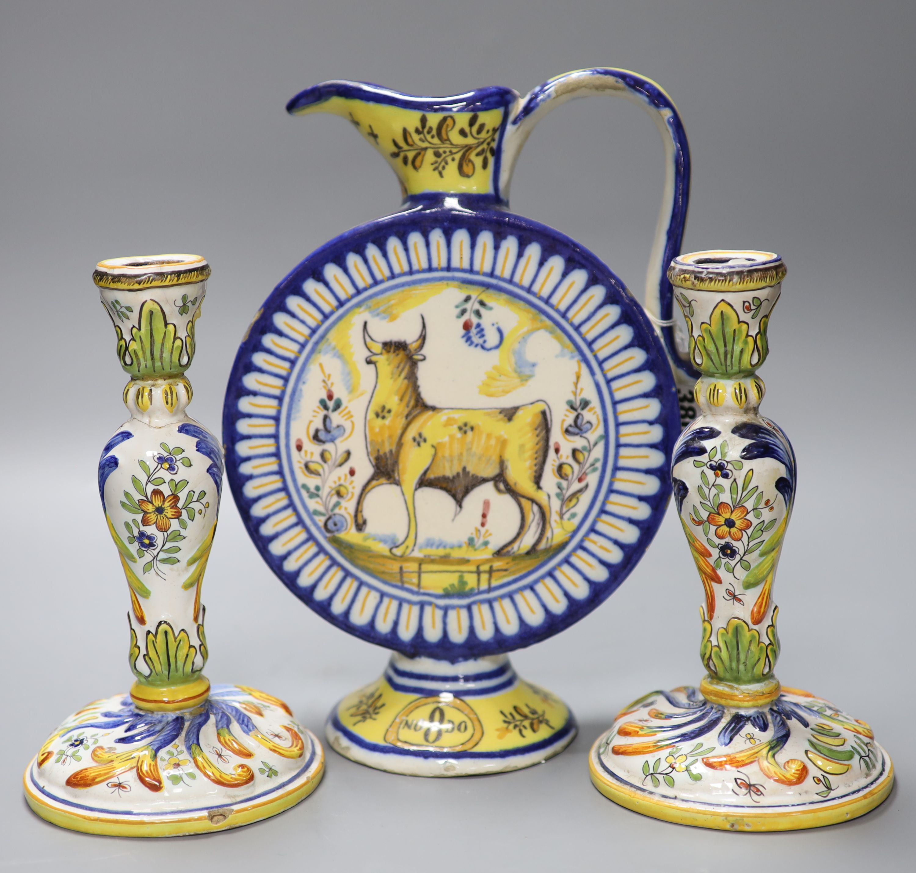 An Italian maiolica flask, height 30cm, and a pair of French faience candlesticks